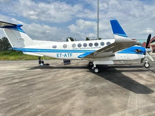 Full side view of the King Air aircraft on the tarmac, showing the blue and white paint scheme.