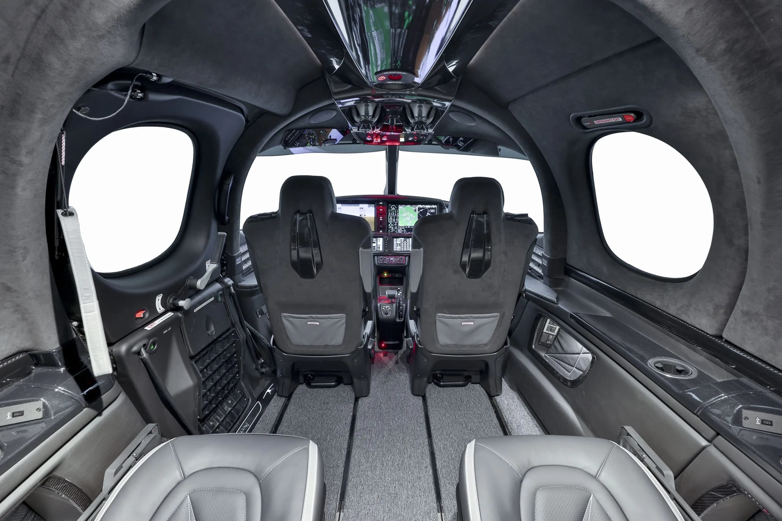 A view from the rear of the Cirrus Vision Jet cabin looking forward towards the cockpit, showing two rows of seats.
