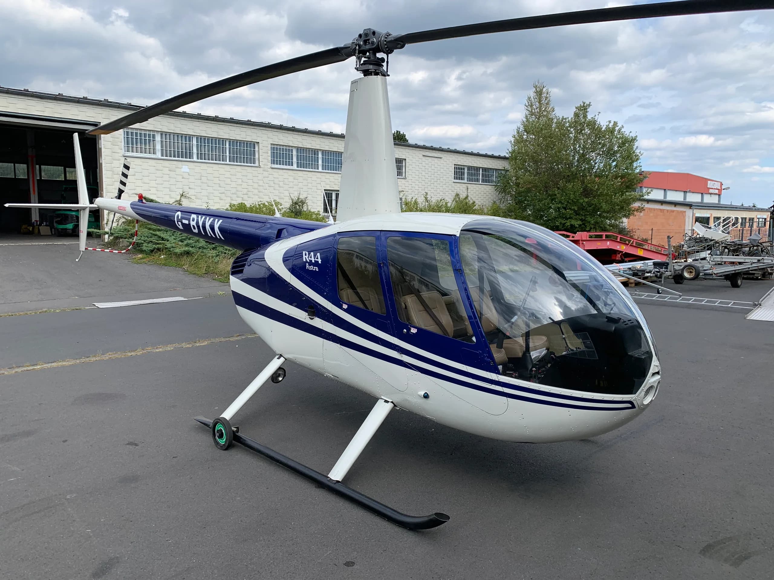 Robinson R44 Raven with blue and white paint scheme at an airport.