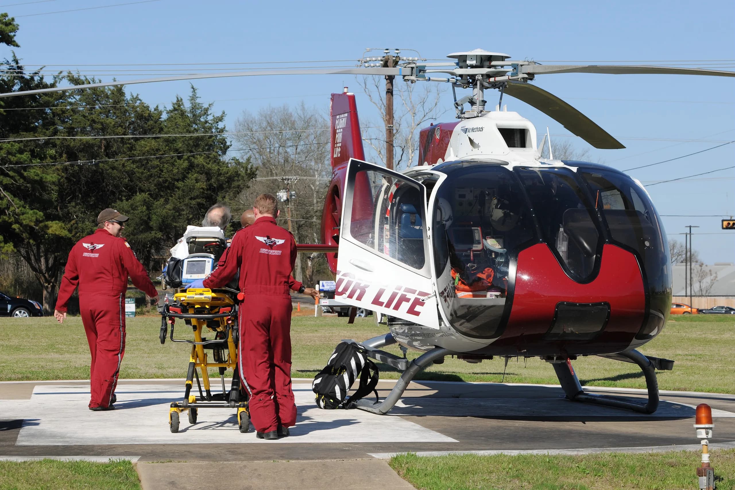Red and white helicopter with medical personnel and equipment.