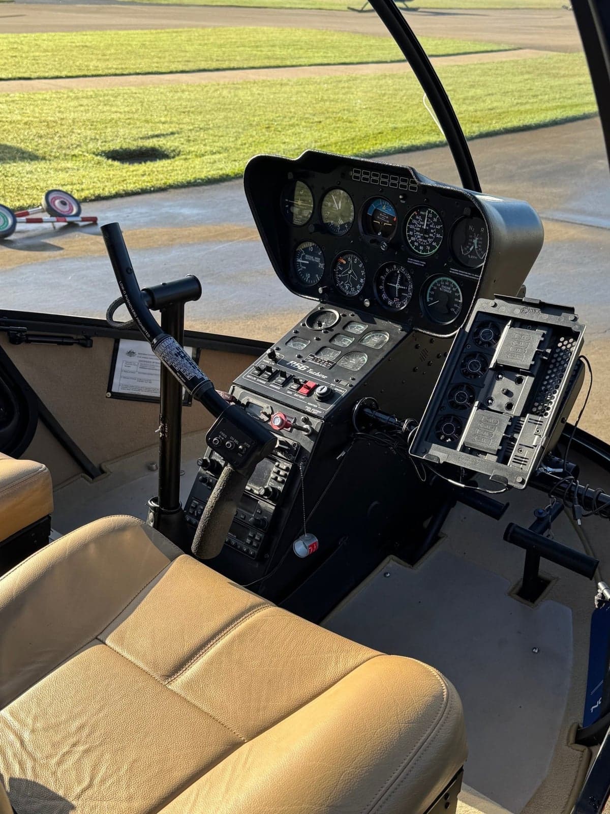 The instrument panel of a Robinson helicopter with tan leather seats.