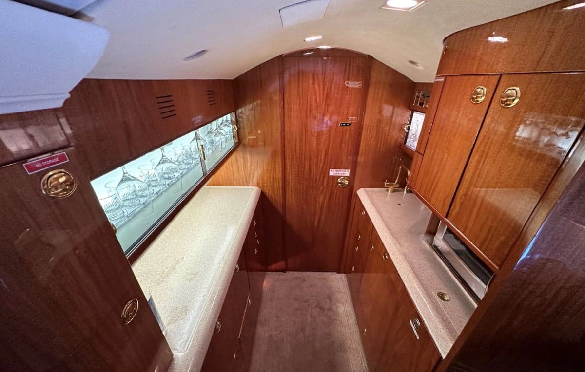 A view of the aircraft galley with wooden cabinets and glassware storage.