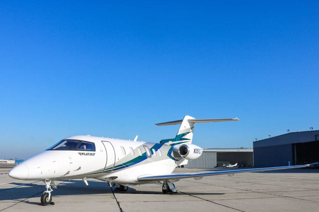 Pilatus PC-24 N357LT parked on the tarmac with a white and teal paint scheme.