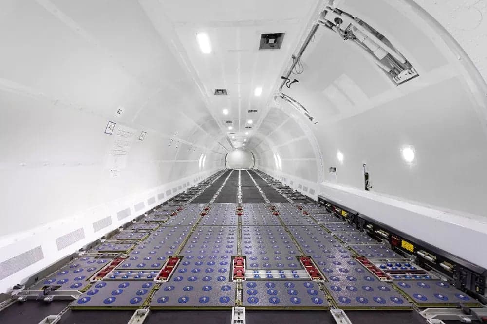 The interior of a cargo plane is empty and ready for loading.