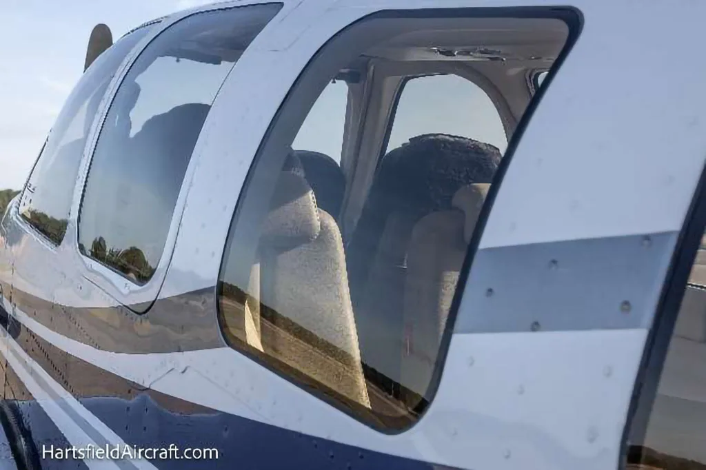 A close-up view of the tan interior seats visible through the windows of the Beechcraft Bonanza N4081.