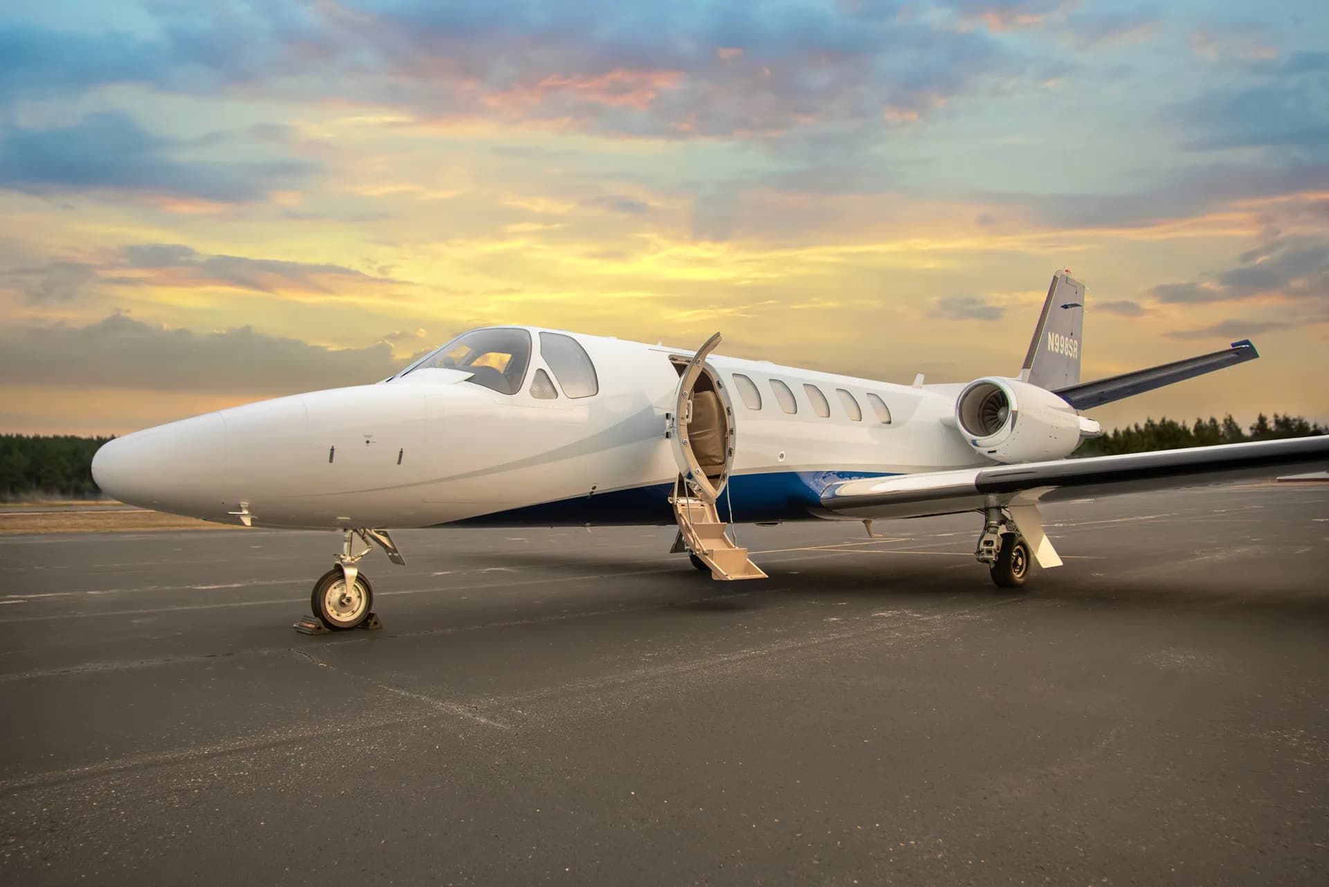 A Citation Bravo aircraft with tail number N998SR is parked on the tarmac with the door open.