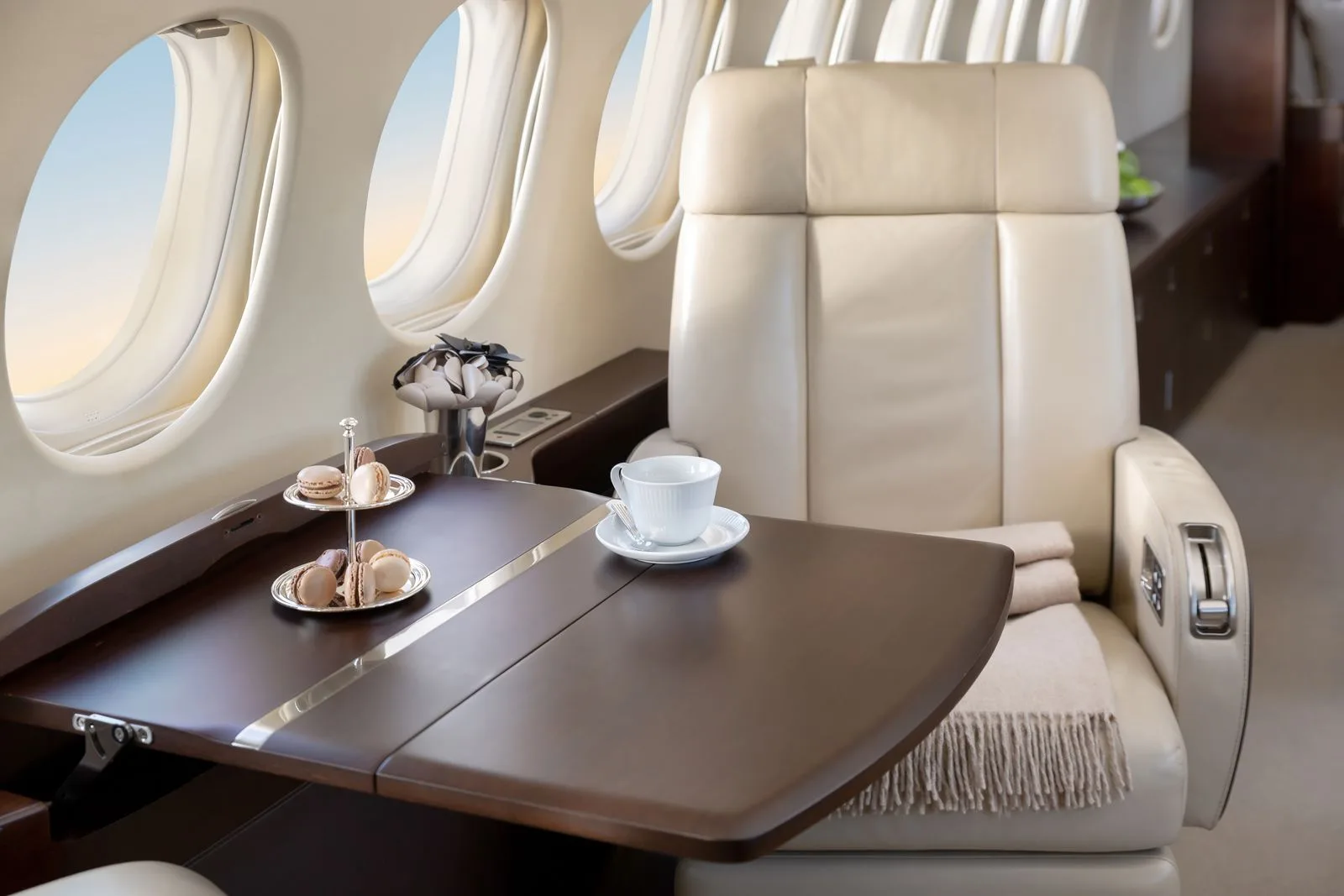 A close up of a leather seat and table in a Falcon jet.