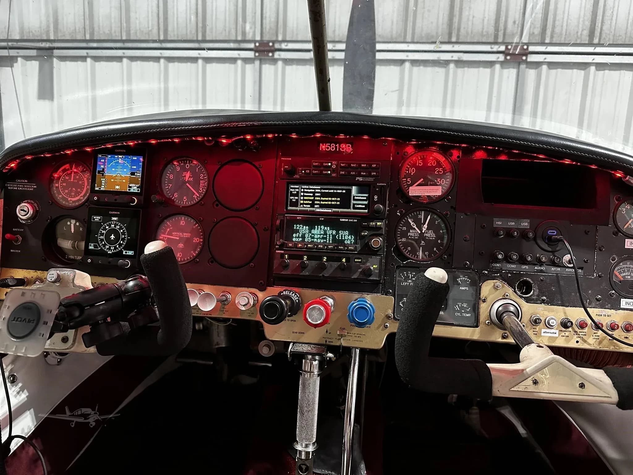 The illuminated cockpit instrument panel of the Mooney M20 Mark 21, showing various gauges and avionics.
