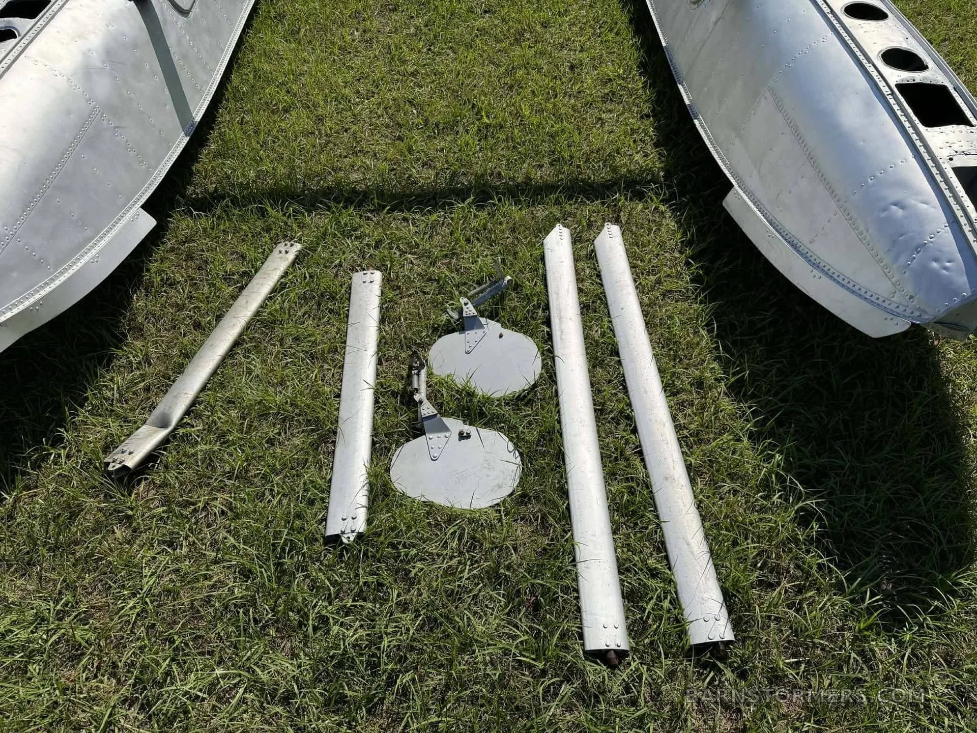 Various components of EDO float barrels laid out on grass.