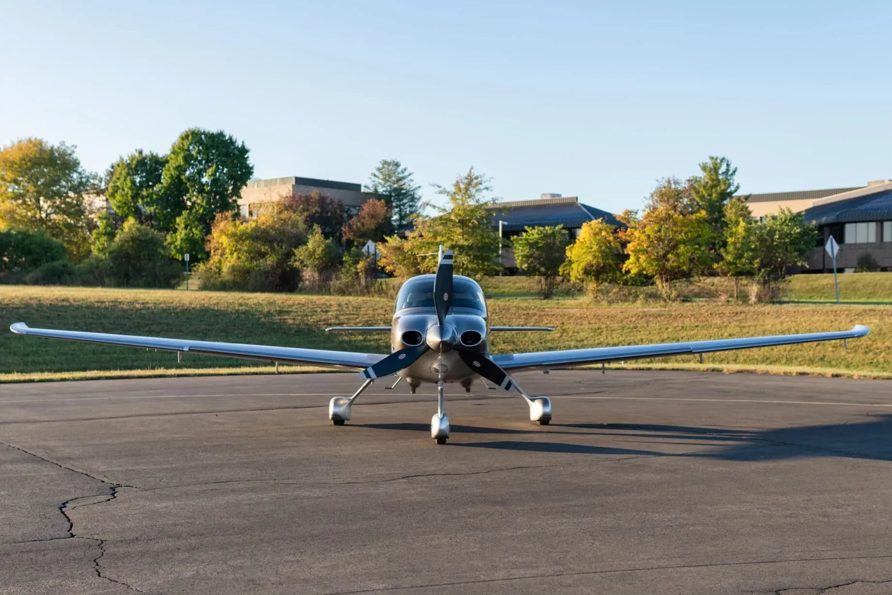 A front view of the silver and grey Cirrus SR22 aircraft (N285WT) with its propeller on an asphalt tarmac.