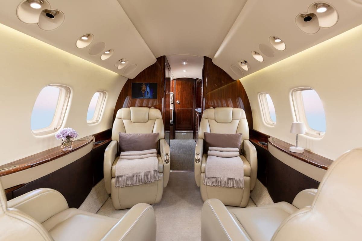 View of the Embraer Legacy 500 cabin with leather seats and wood trim.