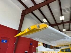 Close-up of the wingtip of a yellow and white Cessna 185 Skywagon.