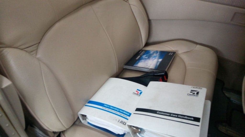 Close up of the Cessna Pilot Operating Handbook and Customer Care Handbook on a seat.