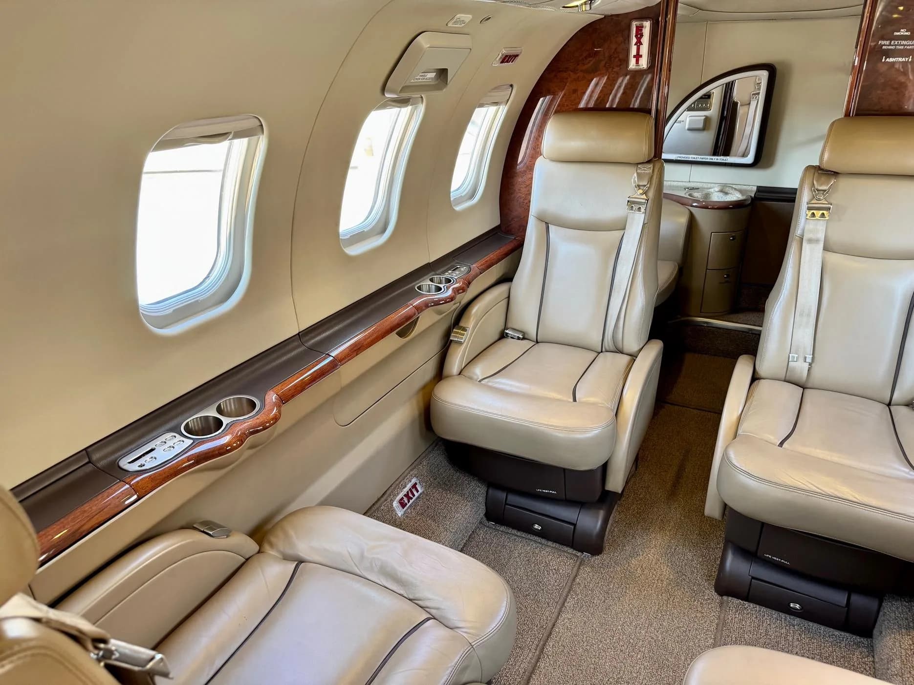 View of the aircraft interior with leather seats and wood trim.