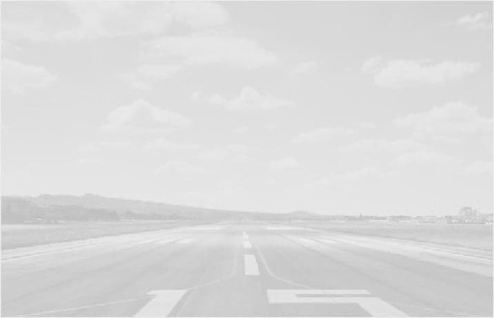 An empty runway on a cloudy day.