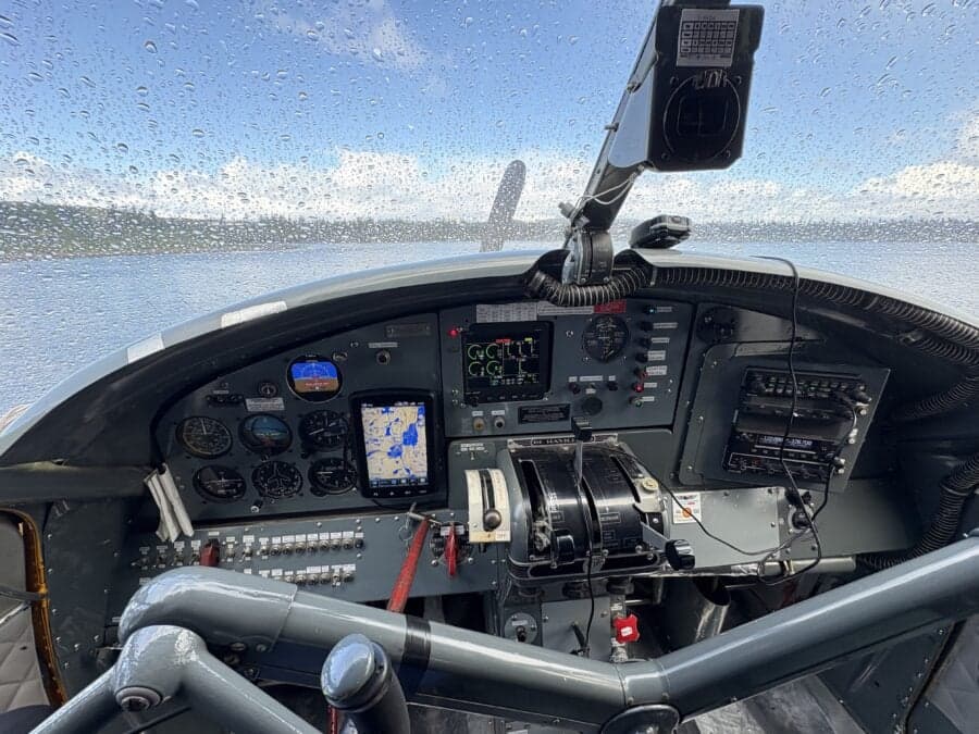 View of the aircraft cockpit with water droplets on the windshield.