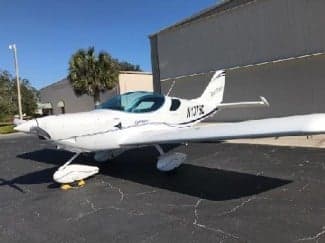 A white Sport Cruiser aircraft with tail number N137SC parked on the tarmac.