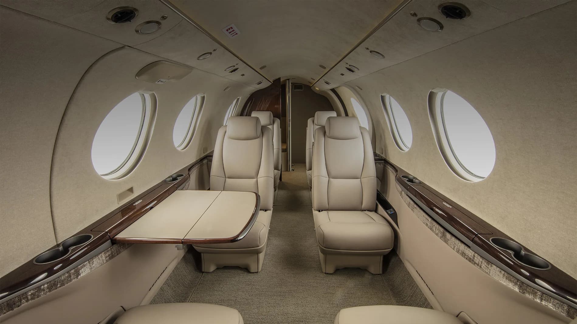 View of the aircraft interior with leather seats and tables.