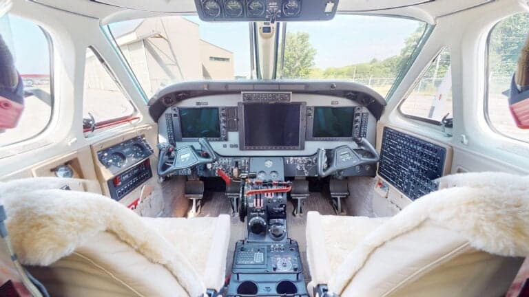 A view of the interior of a King Air aircraft with cream-colored leather seats.