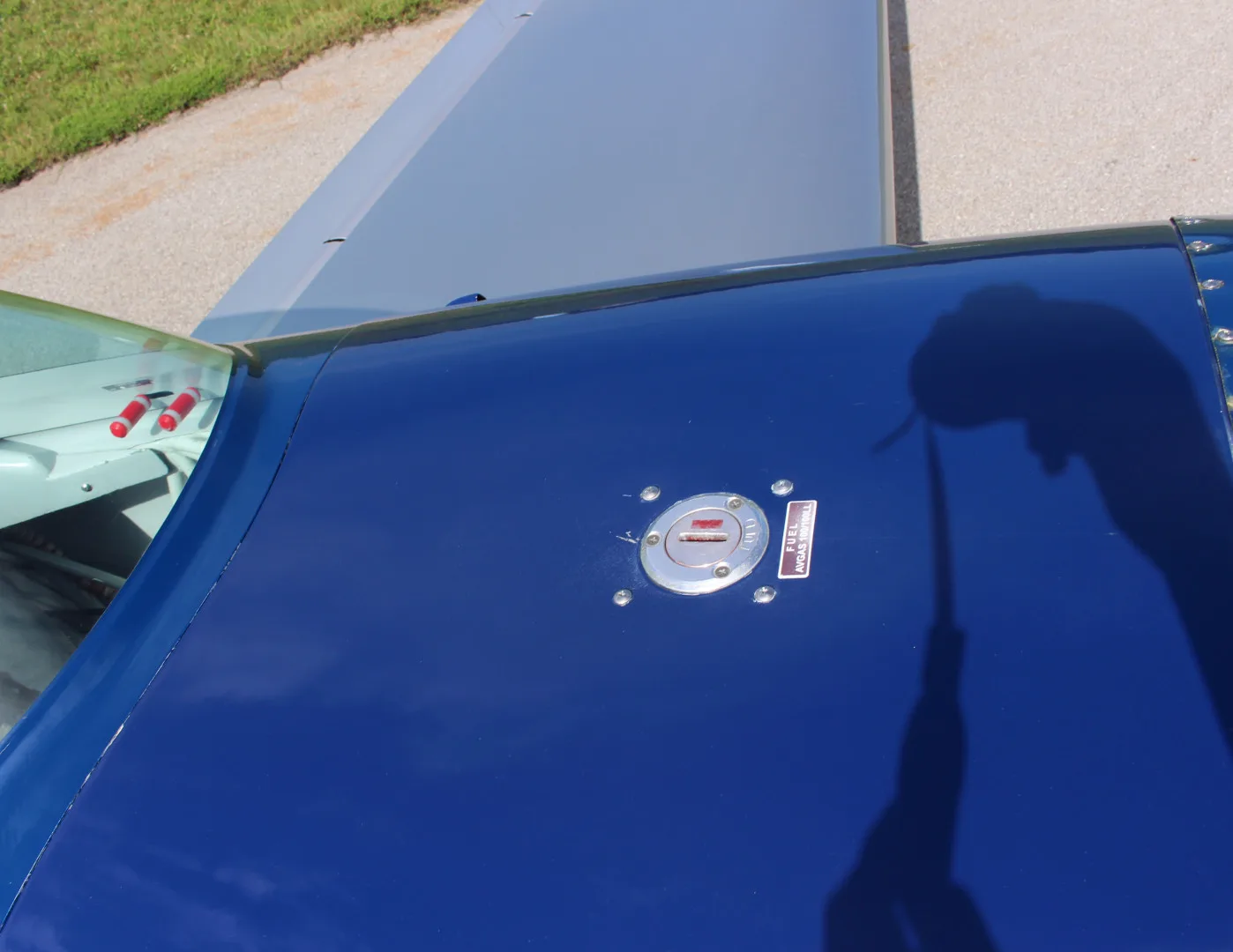 A top-down view of the blue fuselage and wing of the N51E Extra EA-300/L, showing a fuel cap.