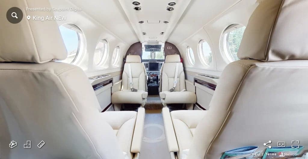 Interior view of a King Air aircraft cabin with cream-colored leather seats.