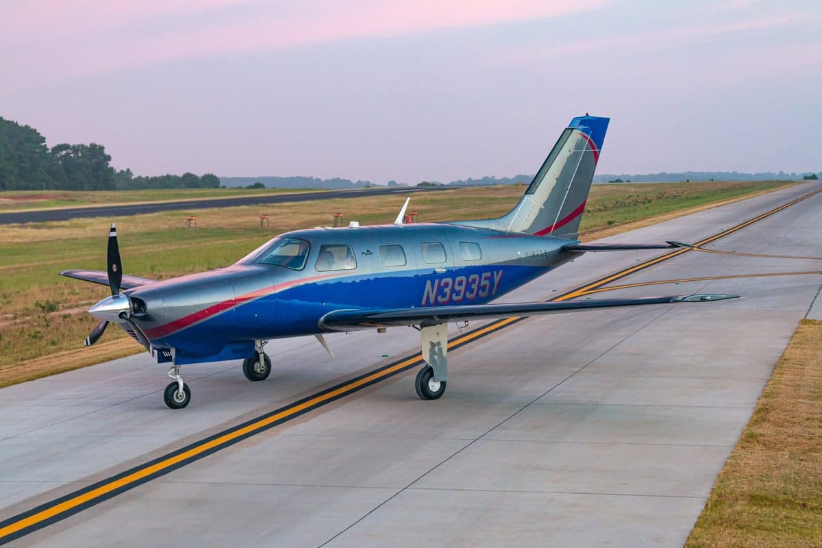 Piper Mirage N3935Y on the runway at dusk.