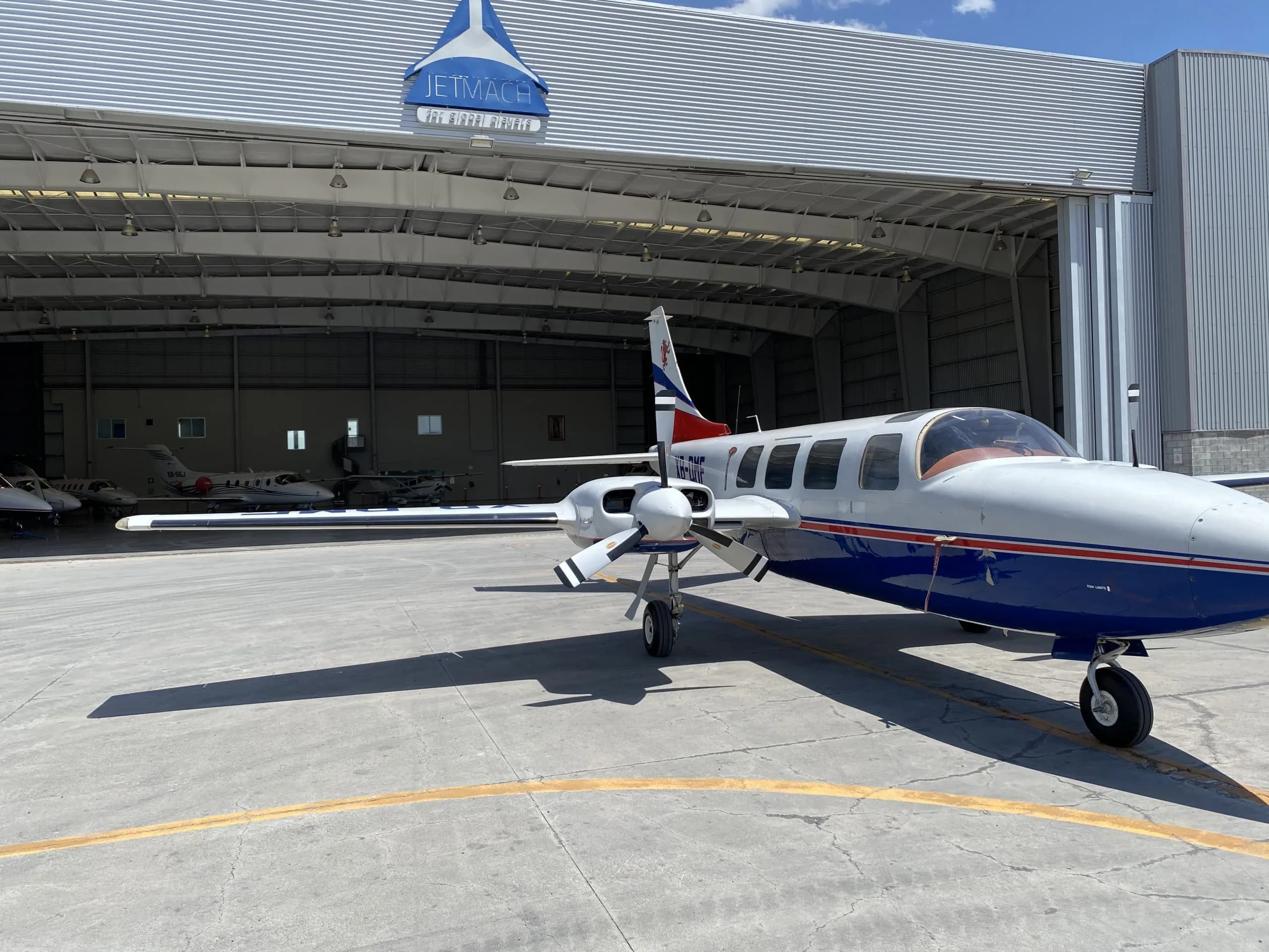 Front side view of the XB-DMF aircraft parked in front of a hangar.