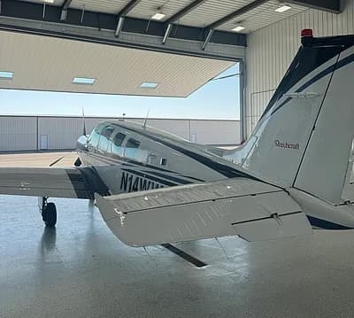 Beechcraft Bonanza in a hangar, rear view with tail number N14WW.