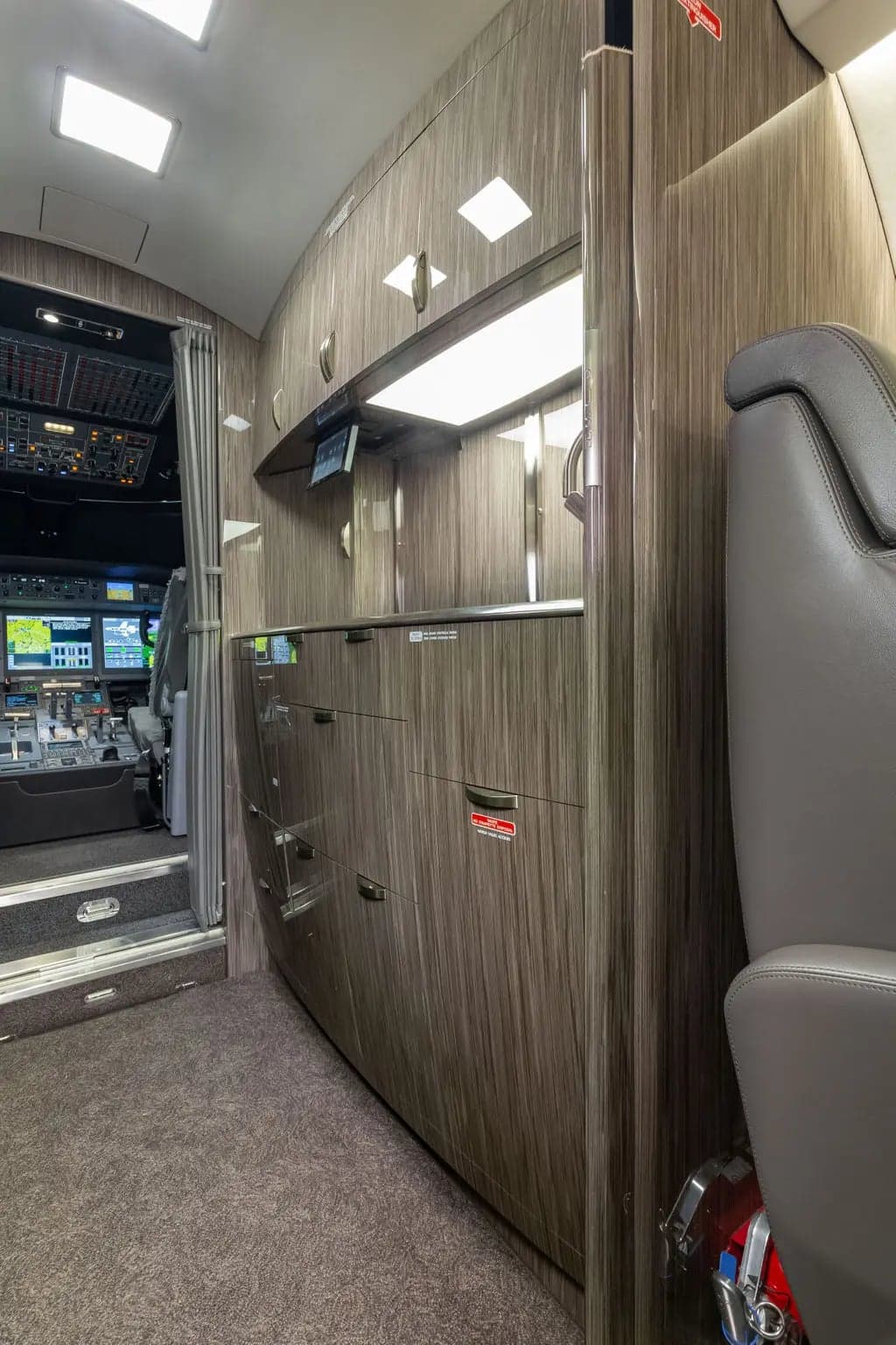 Interior view of the aircraft galley with cockpit in the background.