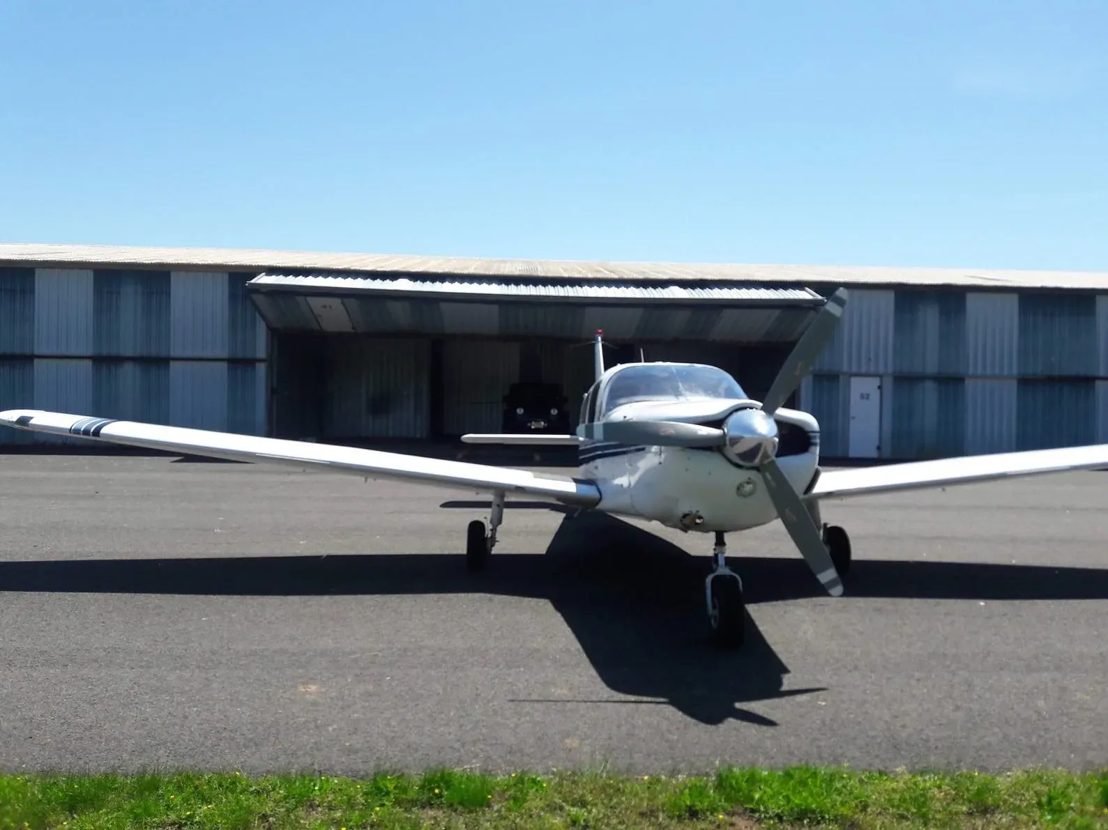 A head-on view of the white Piper PA-32R-300 Cherokee Lance, registration N434DJ, parked on an airfield.