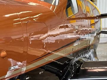 Close-up of the copper and black paint scheme on the Pilatus PC-12 aircraft.