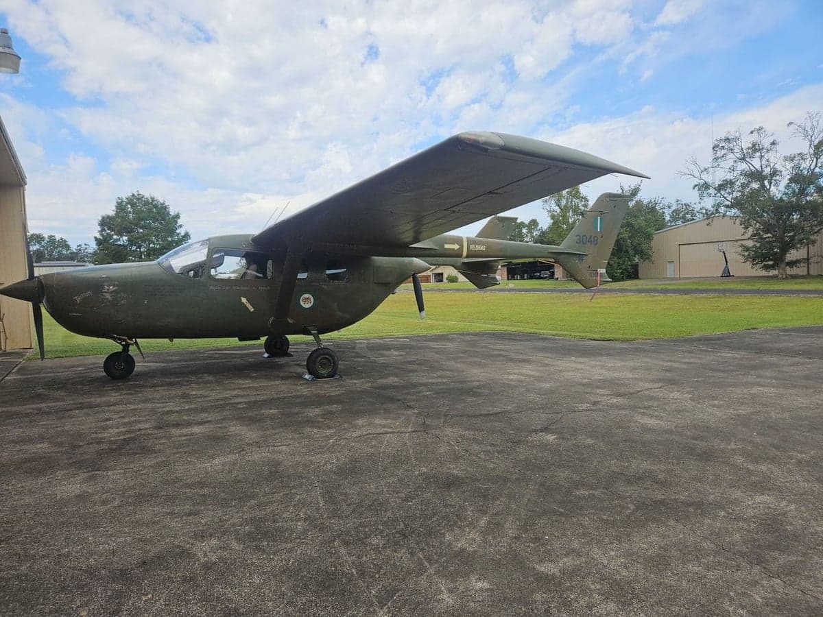 A military-style aircraft with tail number 3048 parked on the tarmac.
