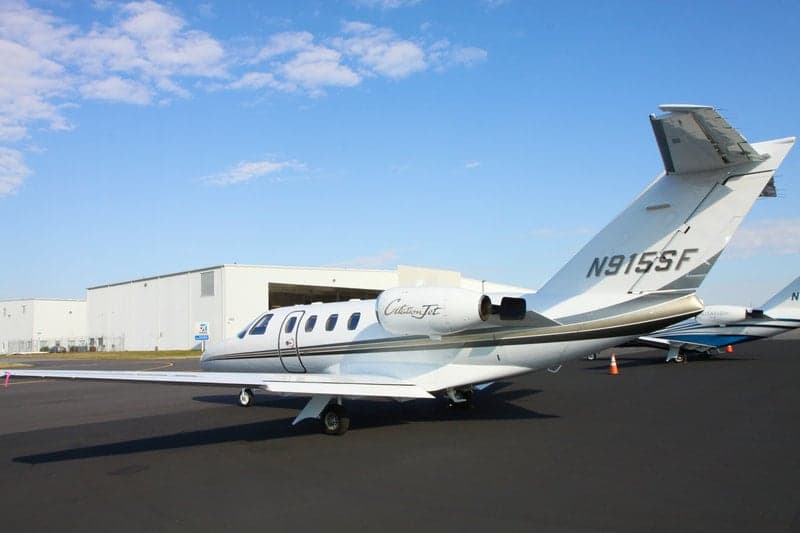 A Citation Jet with tail number N915SF sits on the tarmac in front of a hangar.