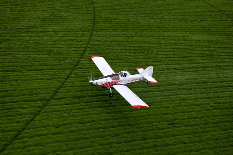 Air Tractor 710P agricultural aircraft spraying crops in a field.