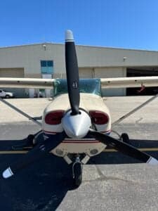 A front view of the Cessna 182 Skylane, showing the propeller and nose.
