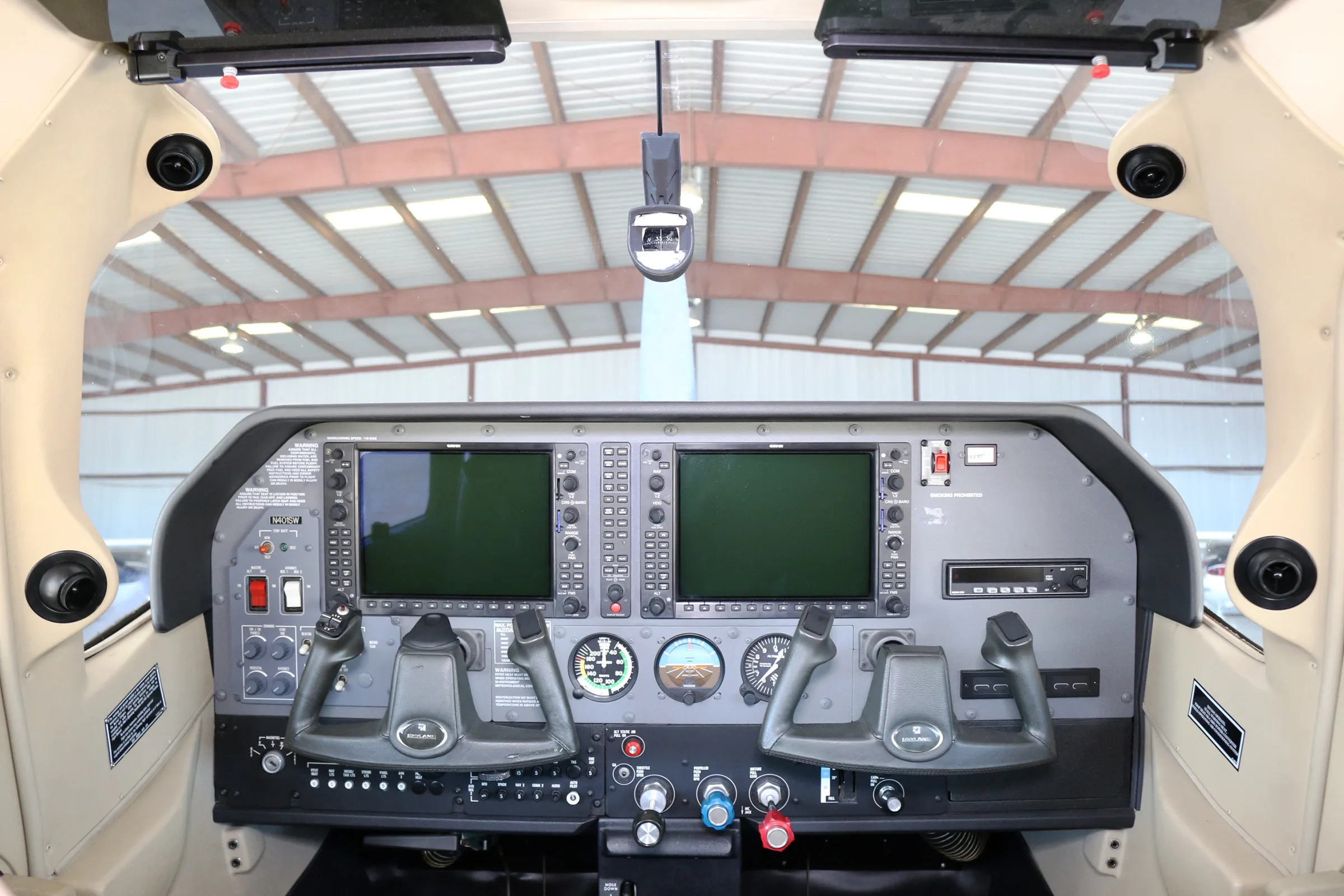 The cockpit instrument panel of a Cessna Skylane aircraft with dual display screens and yokes.