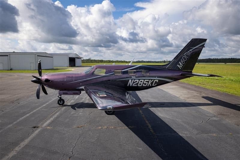 Piper M600 SLS aircraft N285KC parked on the tarmac with a purple and black paint scheme.