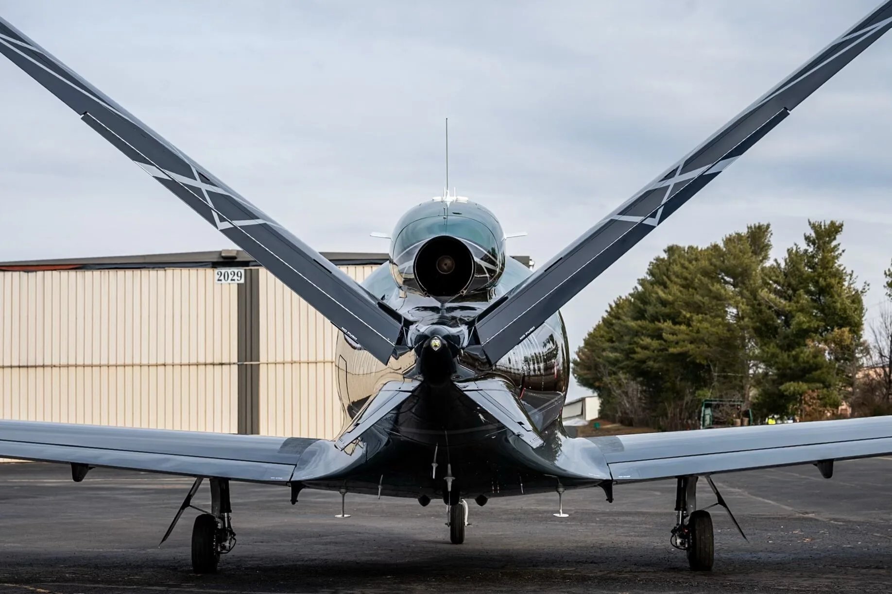 A rear view of the Cirrus Vision Jet N520TD showing its V-tail and jet engine exhaust.