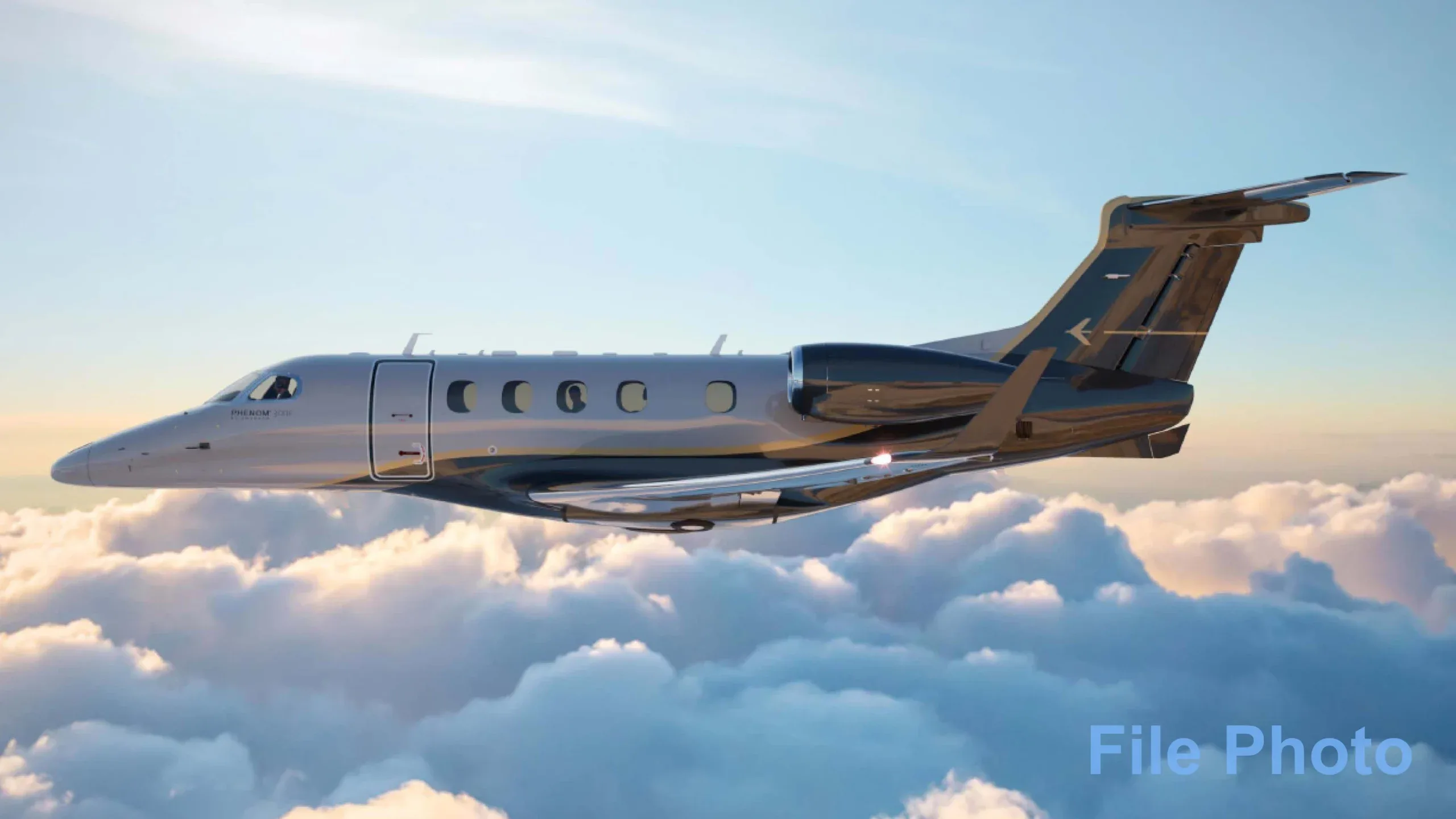 Stock photo of a Phenom 300E in flight above the clouds.