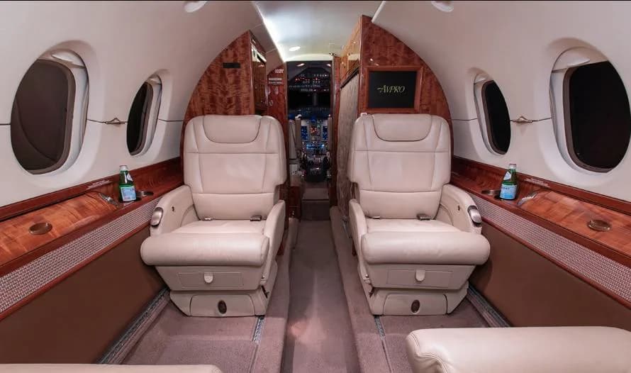 The interior of a Citation jet with cream-colored leather seats.