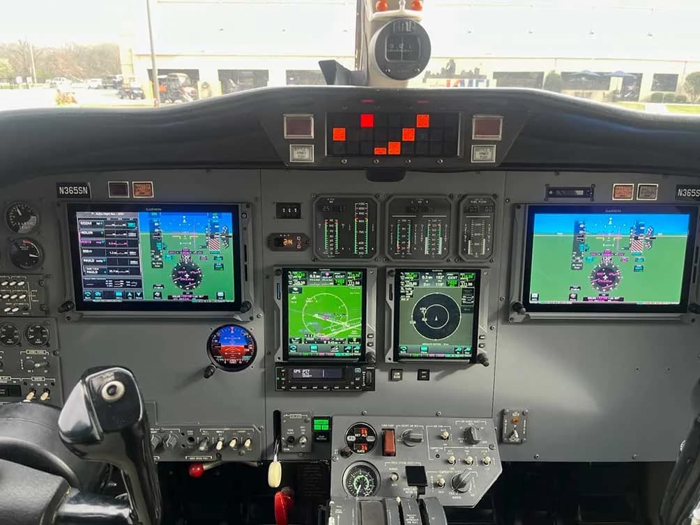 The cockpit of an aircraft featuring multiple digital displays and flight controls.