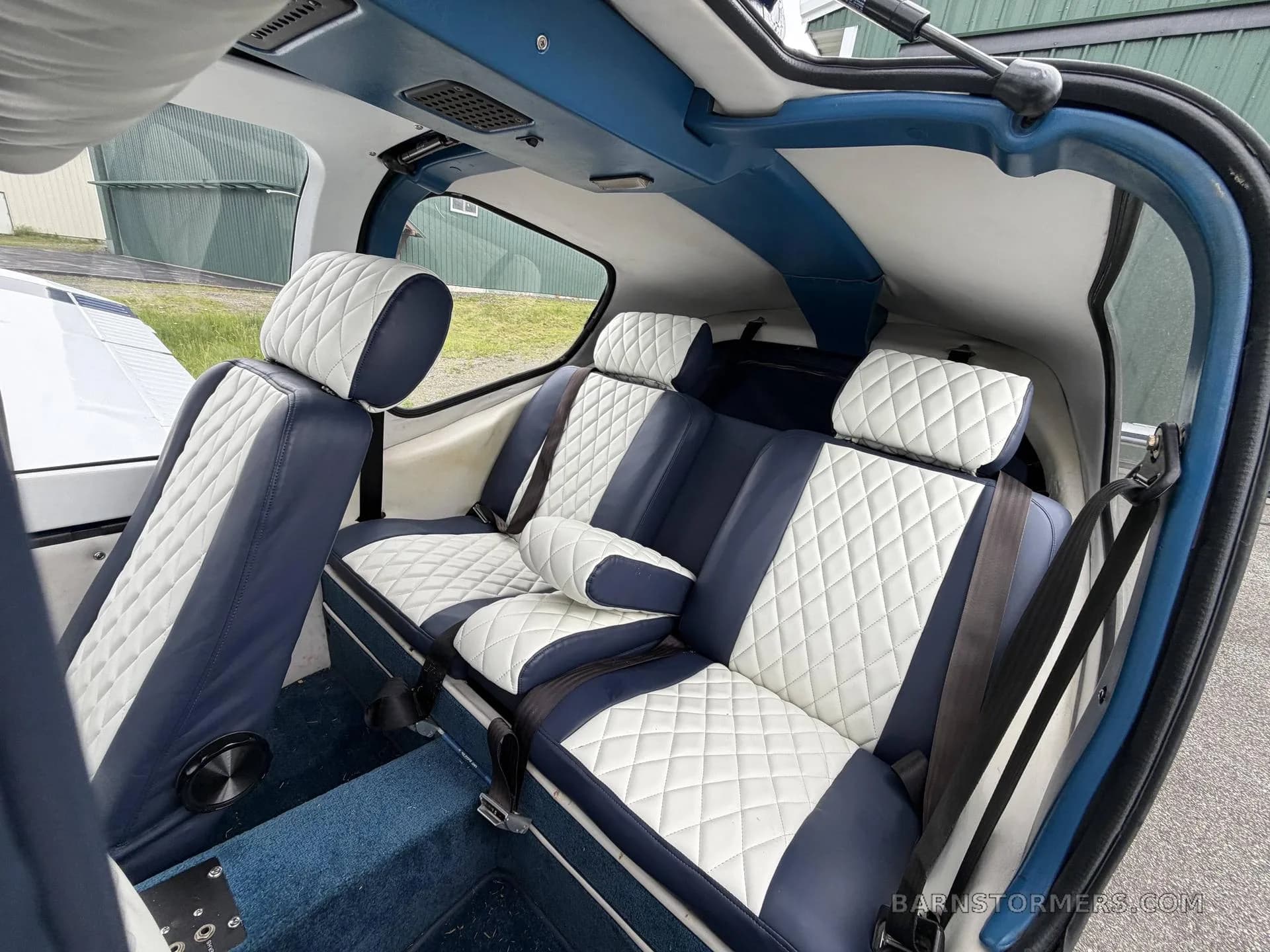 The rear cabin of a Socata Trinidad TB20, with blue and white quilted leather seats.