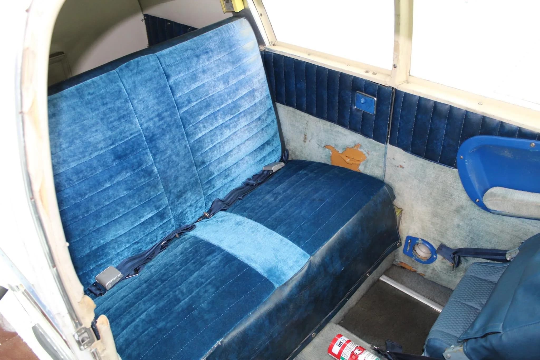 Interior view of the blue fabric rear seats of a small aircraft.