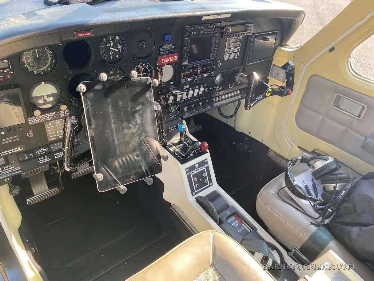 View of an aircraft cockpit showing the instrument panel, center console, and pilot's seat.