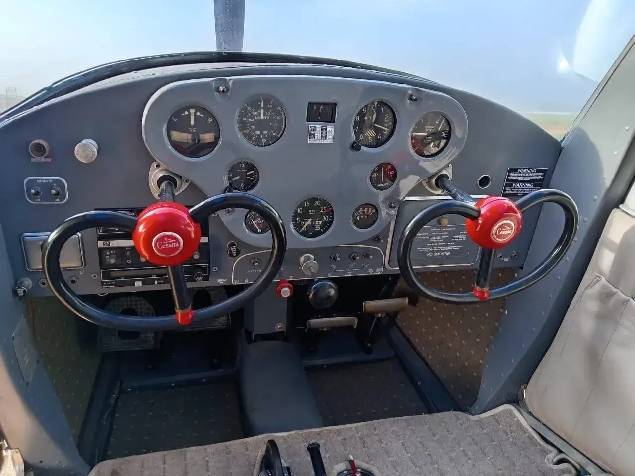 The cockpit of a Cessna 170 aircraft, showing the instrument panel and controls.