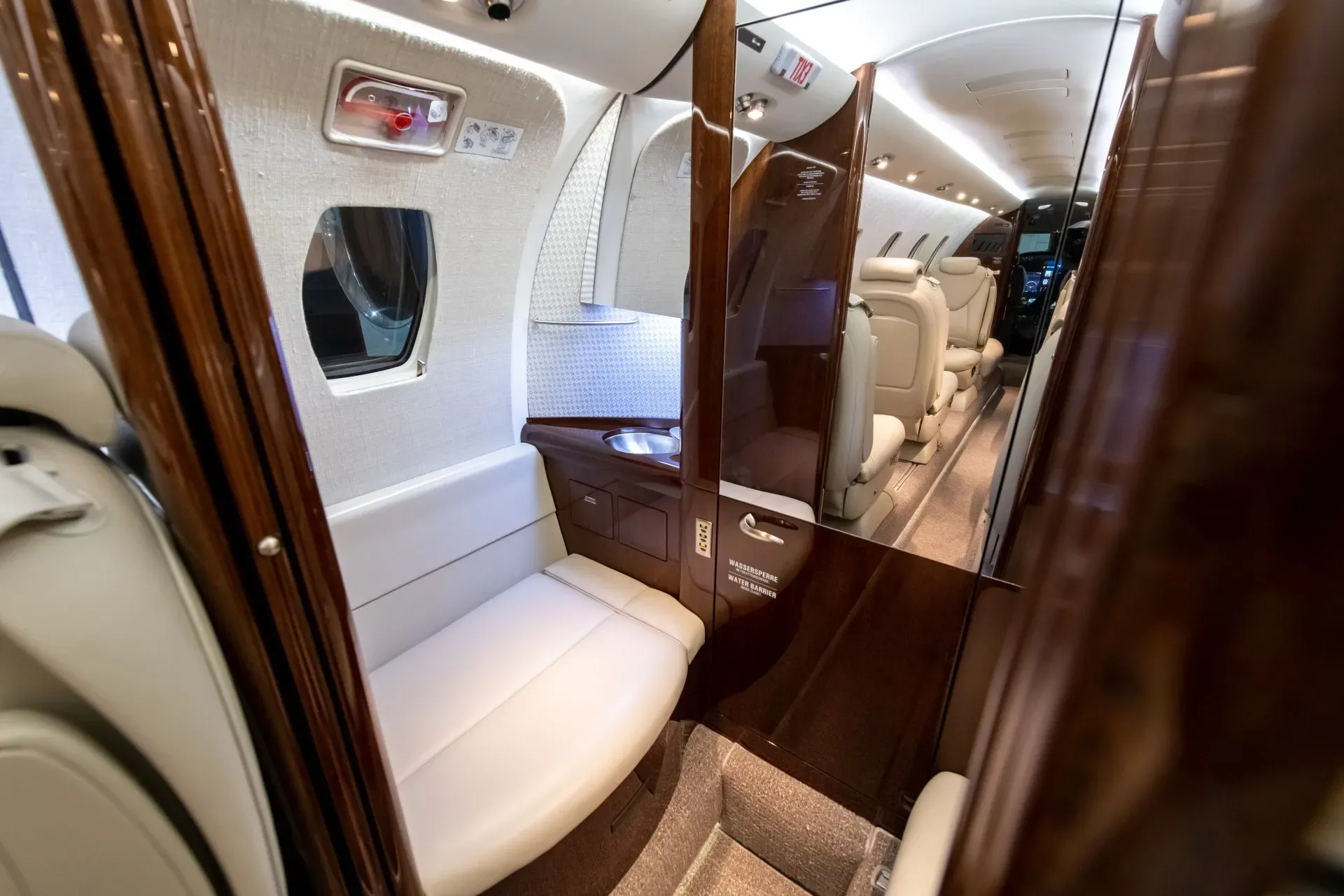 A view of the lavatory and cabin of a business jet.