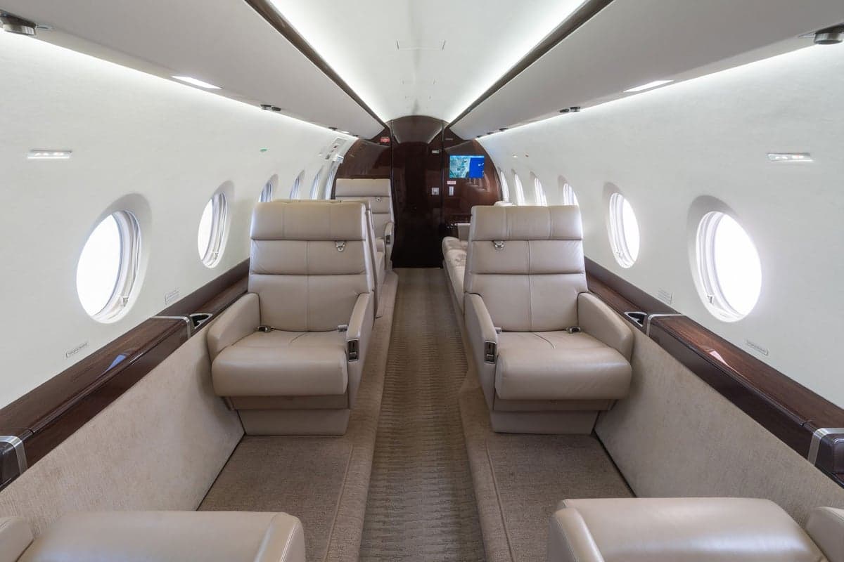 A view of the aircraft's interior with leather seats and oval windows.
