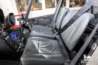 Interior view of the cockpit and seats of a helicopter.