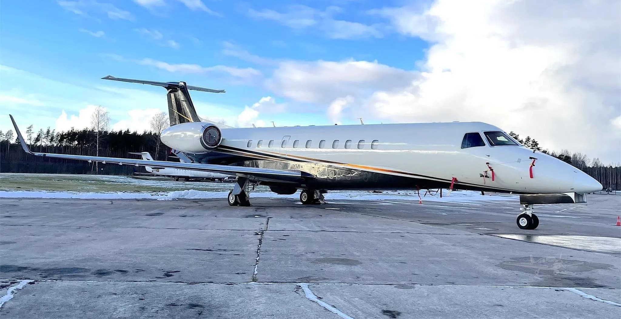 An Embraer Legacy 650 on the tarmac on a sunny day.