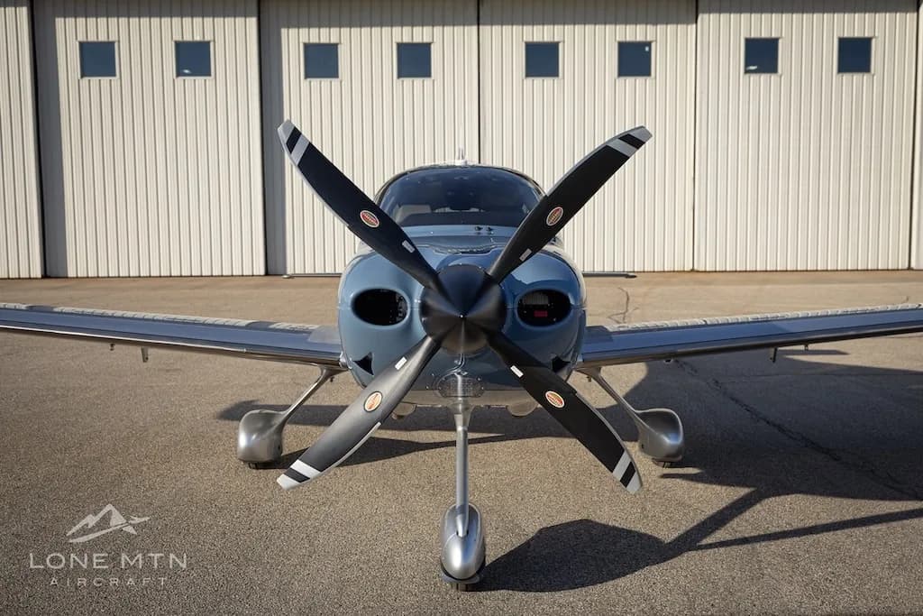 A head-on view of the Cirrus SR22T aircraft, N902KD, showing its propeller and nose.